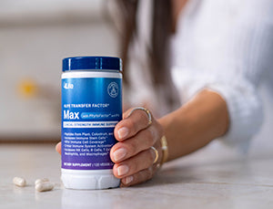 Woman setting a bottle of 4Life Transfer Factor Max on a kitchen counter